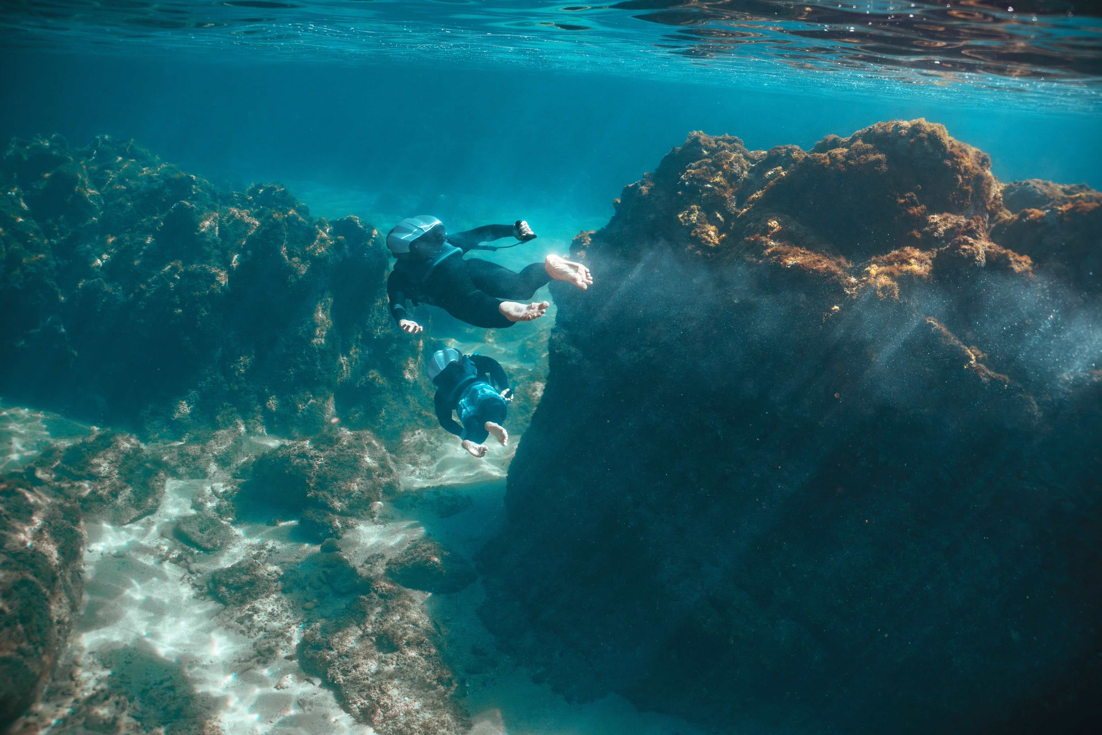 Person Jetpack with CudaJet near a coral reef with sunlight filtering through the water.